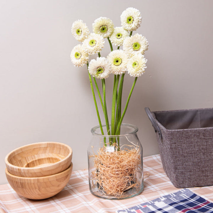 Bright pink Gerbera flowers from the Mona collection by Flowranow, displayed in a bouquet with green leaves.